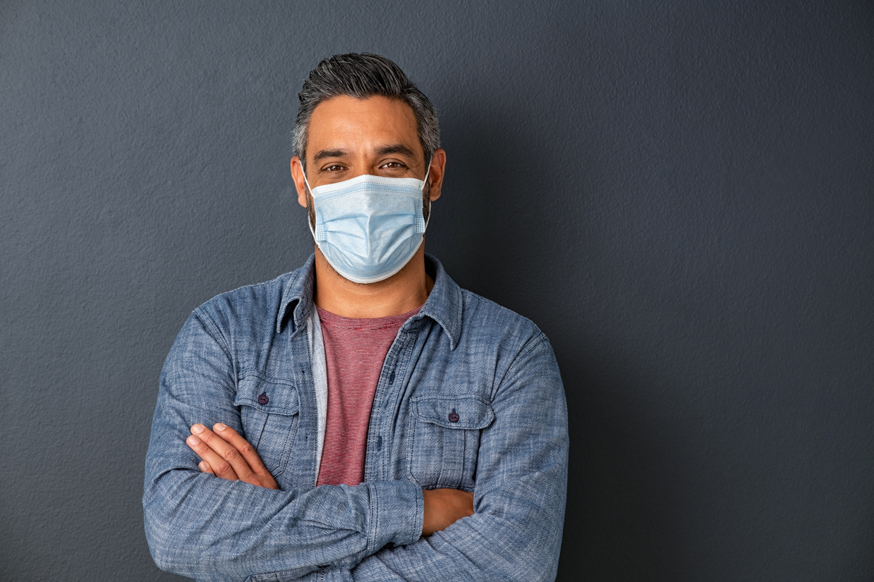 Man Wearing Face Mask on Grey Wall